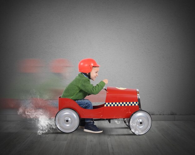 Side view of man sitting in toy car against wall