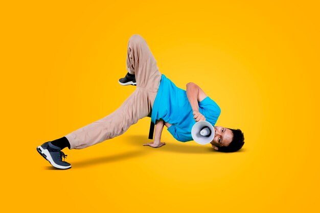 Side view of man skateboarding against yellow background