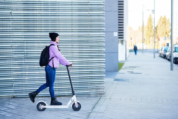 Photo side view of man skateboarding on footpath