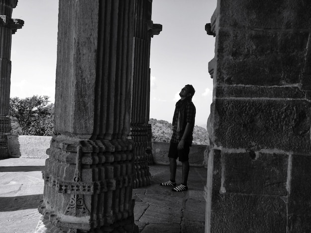 Foto vista laterale di un uomo in piedi tra le colonne del palazzo