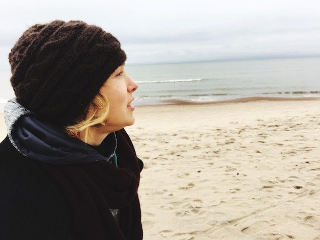 Foto vista laterale di un uomo in piedi sulla spiaggia contro il cielo