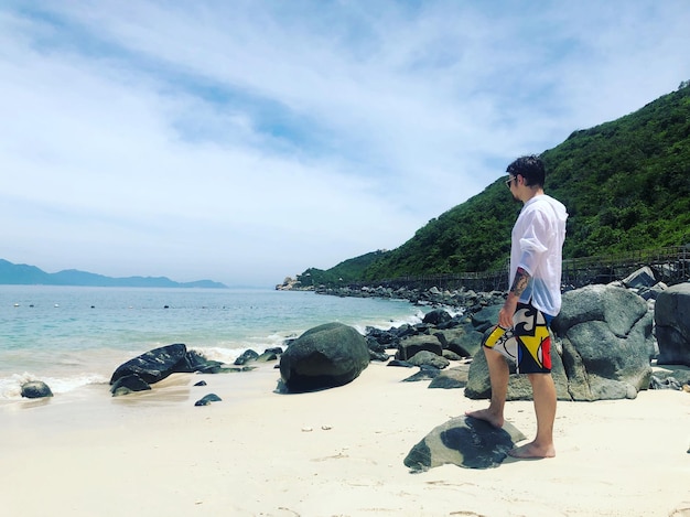 Foto vista laterale di un uomo in piedi sulla spiaggia