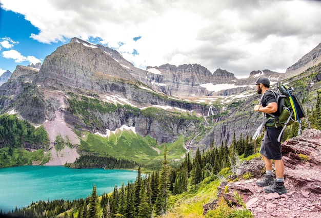 Side view of man standing by lake on mountain