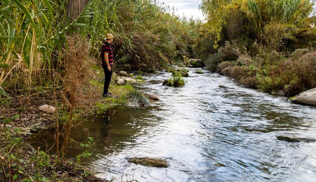 Side view of man standing by river