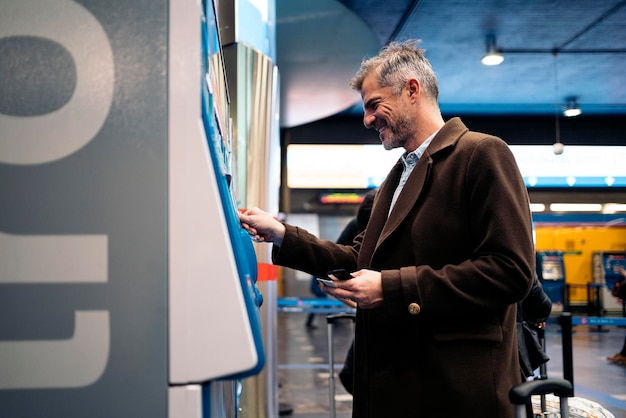 side view of man standing near ticket vending machine