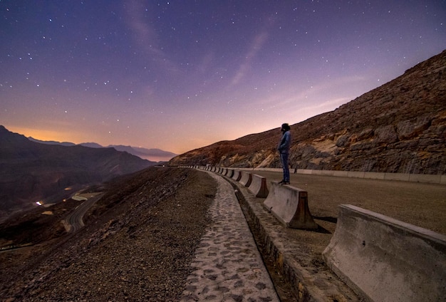 Foto vista laterale di un uomo in piedi sulla strada di notte