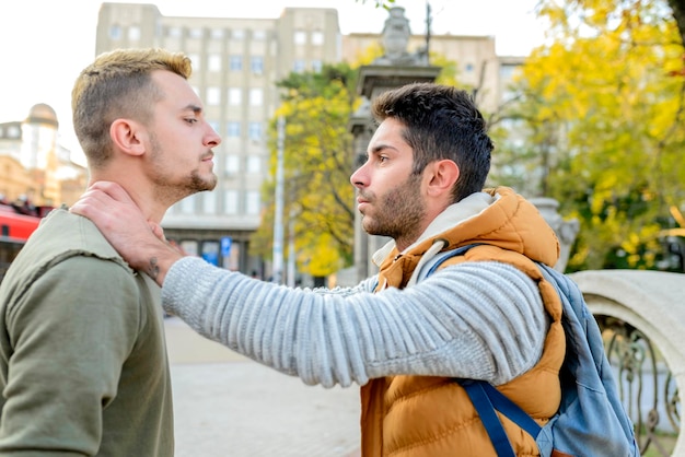 Side view of man strangling friend in city