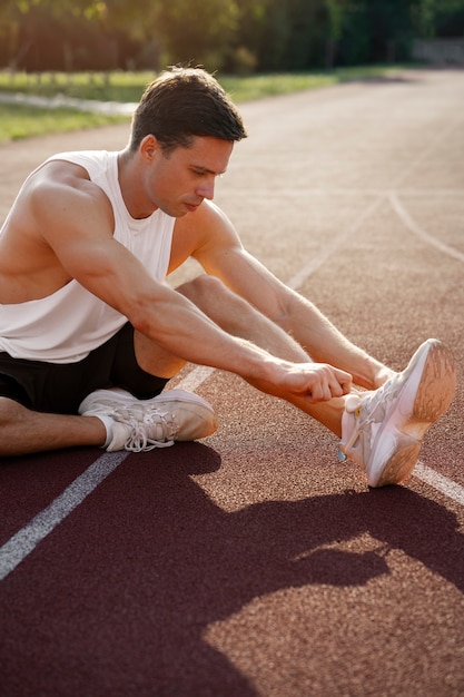 Photo side view man tying shoelaces