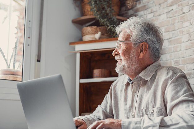 Photo side view of man using digital tablet while standing at home