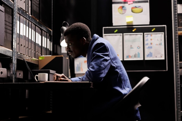 Photo side view of man using laptop at home