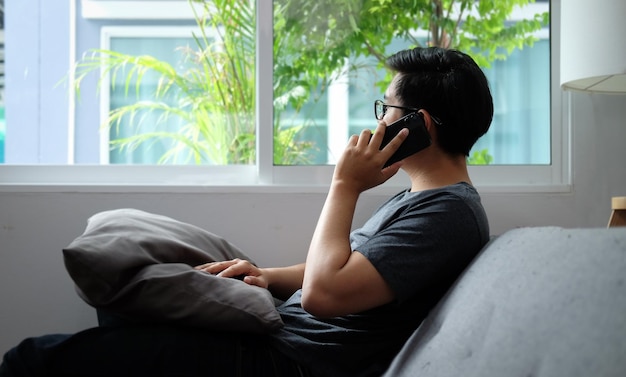Side view of man using mobile phone at home