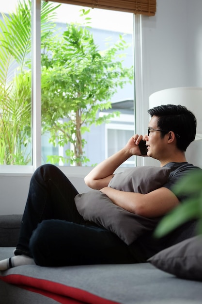 Side view of man using mobile phone at home