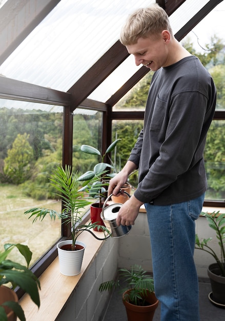 Side view man watering plant