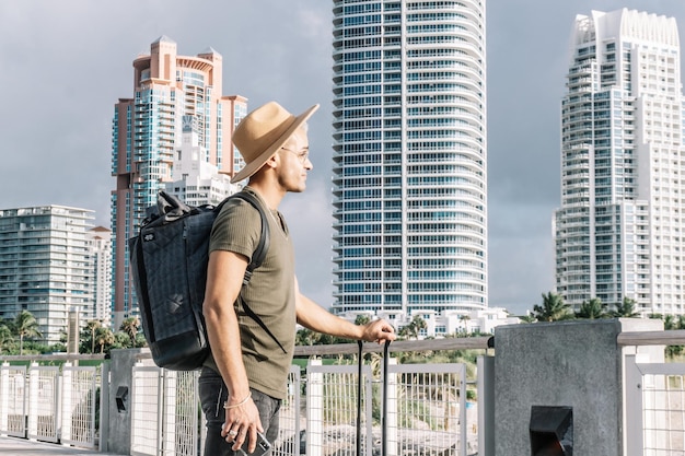 Side view man wearing a hat with a backpack