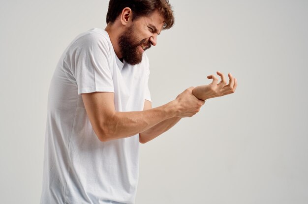 Side view of man with arms crossed standing against white background