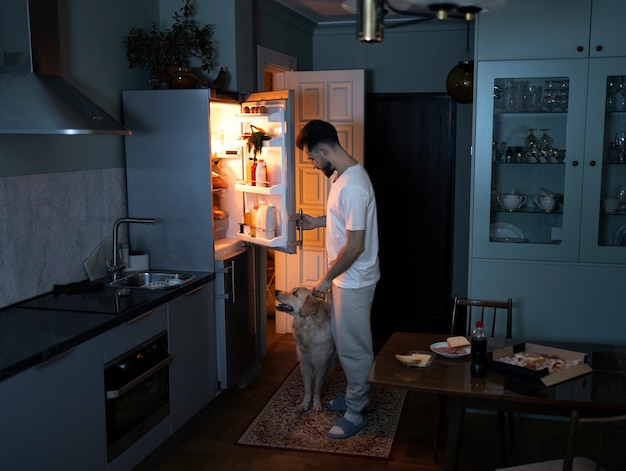 Photo side view man with dog in kitchen