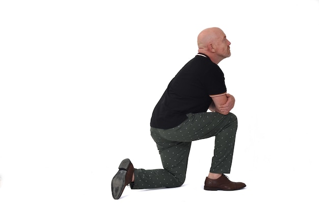 Side view of man with on  knee on floor looking up on white background on white background