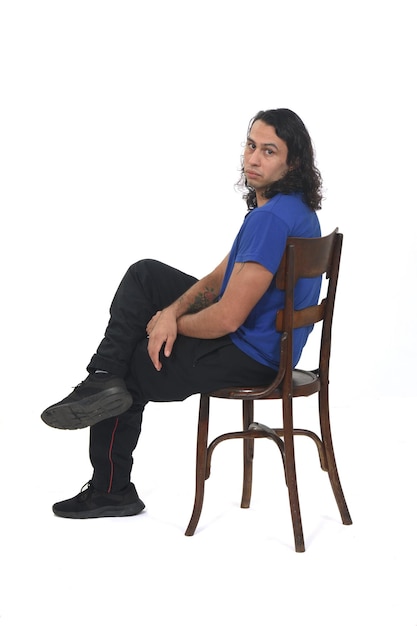 Photo side view of a man with sportswear sitting on chair legs on white background