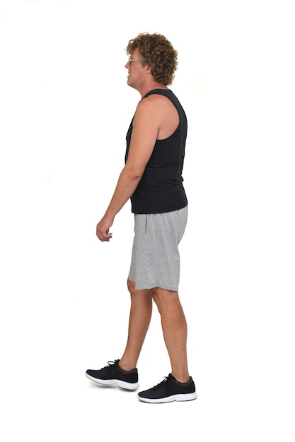 Side view of a man with sportswear walking on white background