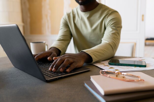 Uomo di vista laterale che lavora al computer portatile