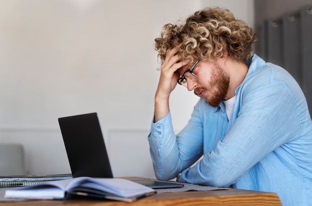 Side view man working with laptop