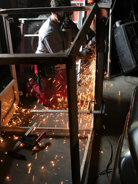 Foto vista laterale di un operaio manuale che lavora in fabbrica