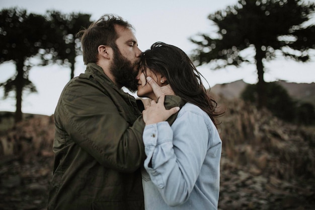 side view of mid adult couple kissing on field