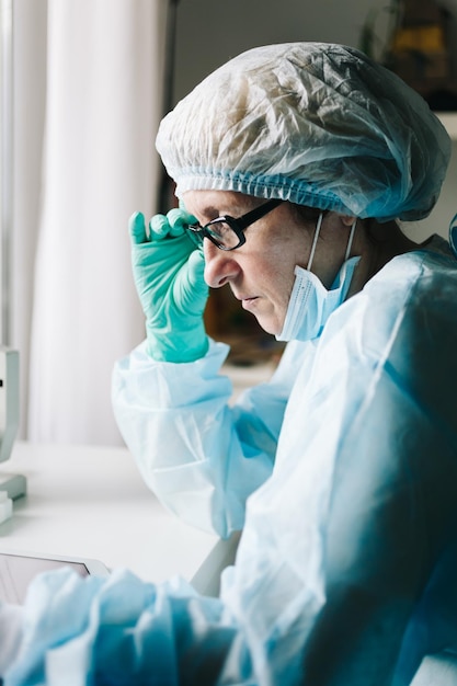 Side view of mid age female scientist working on tablet in laboratory