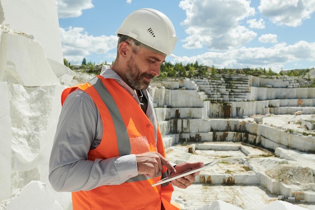 Side view of middle aged bearded foreman or manager with tablet