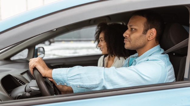 Side view of millennial arab couple posing in new auto