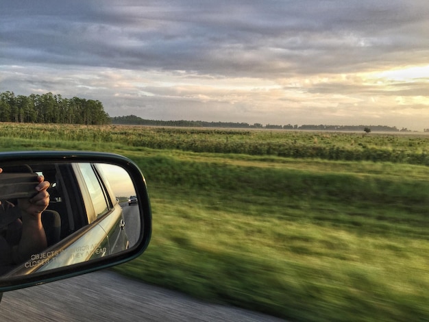 Side-view mirror of car on field