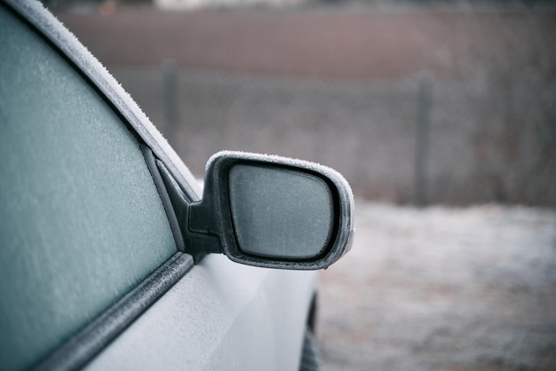 Side view mirror covered with hoarfrost frosty morning