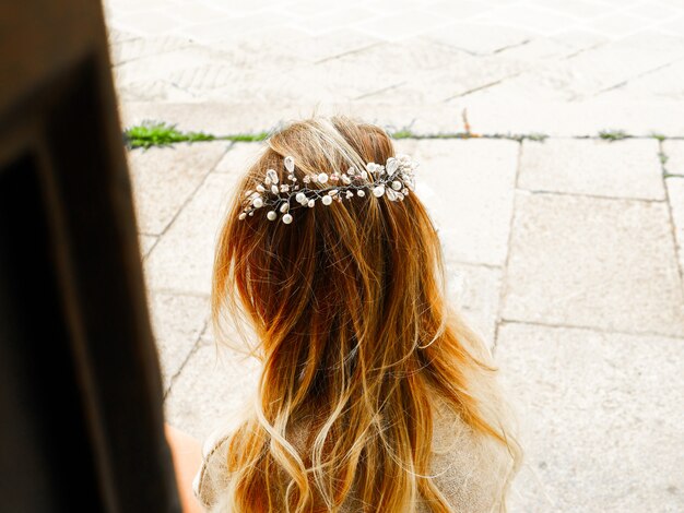 Side view of modern bride in hairstyle decorated by fancy beaded hair accessory. Hair wedding concept. Crystal glass wreath on wavy hair. Copy space