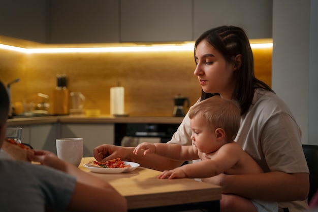 Photo side view mother and baby with food