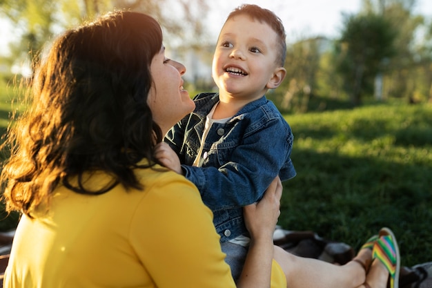 Foto bambino sorridente della holding della madre di vista laterale