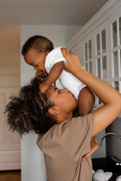 Photo side view mother kissing baby