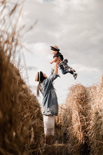 Photo side view of mother lifting son at farm