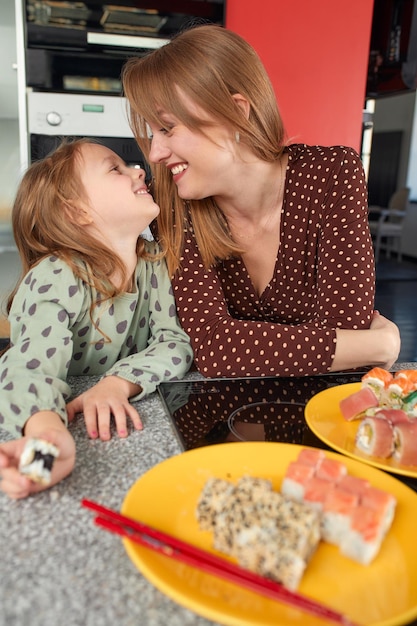 Side view of mother and woman sitting at home