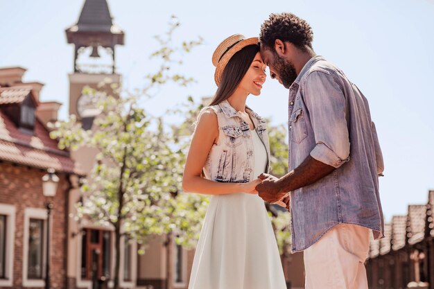 Side view of multiracial couple holding hands together on the street at daytime