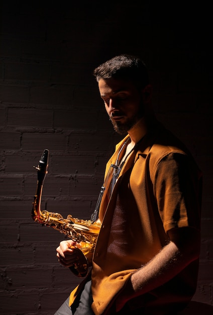 Photo side view of musician holding a saxophone