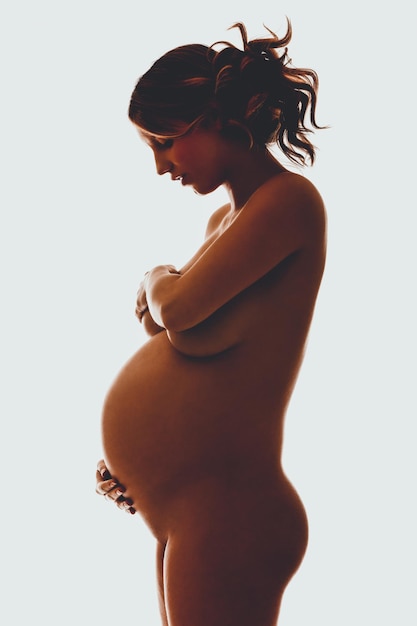 Photo side view of naked pregnant woman standing against white background