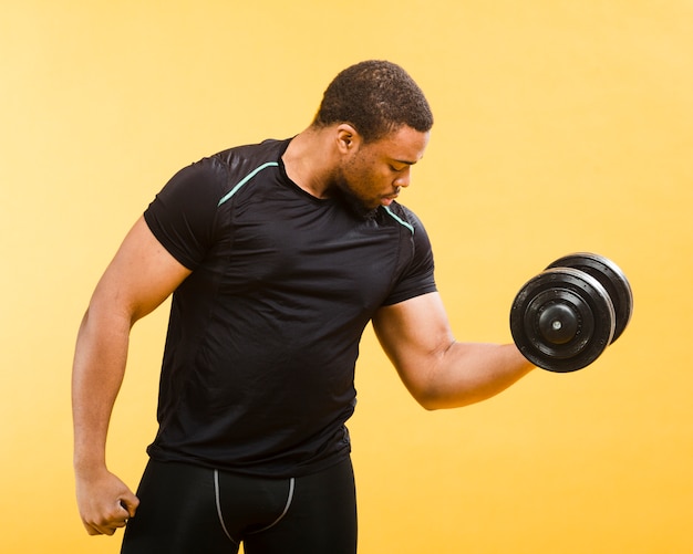 Фото Взгляд со стороны атлетического человека держа весы в обмундировании спортзала