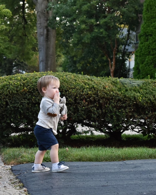 Фото Боковой вид мальчика, стоящего на дороге