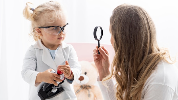 Фото Вид сбоку на милый малыш в защитных очках, изучающий науку