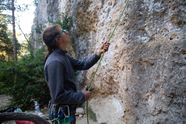 Фото Боковой вид туриста, держащего веревку, стоящего у скалы