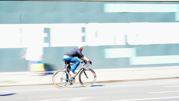 写真 都市で自転車に乗っている男の横の景色