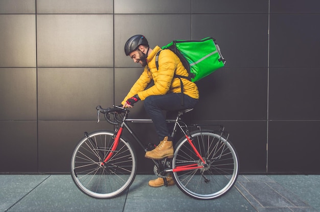 写真 壁に背を向けて自転車に乗って座っている男のサイドビュー