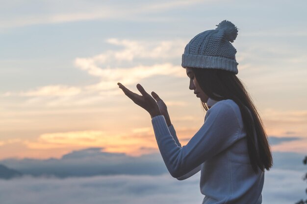 写真 夕暮れの空に向かってスマートフォンを使っている男の横の景色