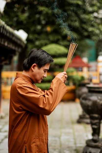 写真 お香と寺院で宗教的な男の側面図