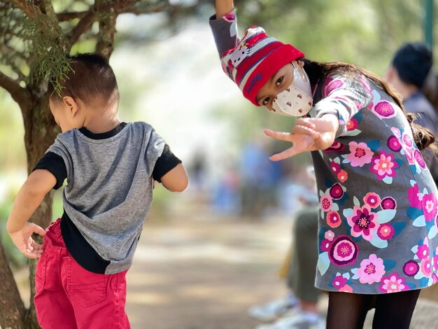 写真 両腕を上げて遊んでいる兄弟姉妹の横景色